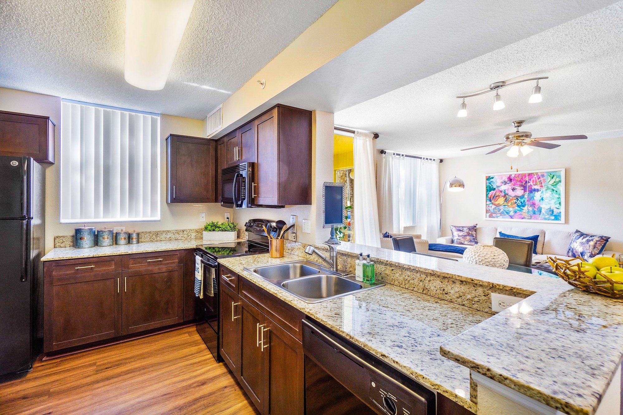 A kitchen with granite countertops and wooden cabinets.